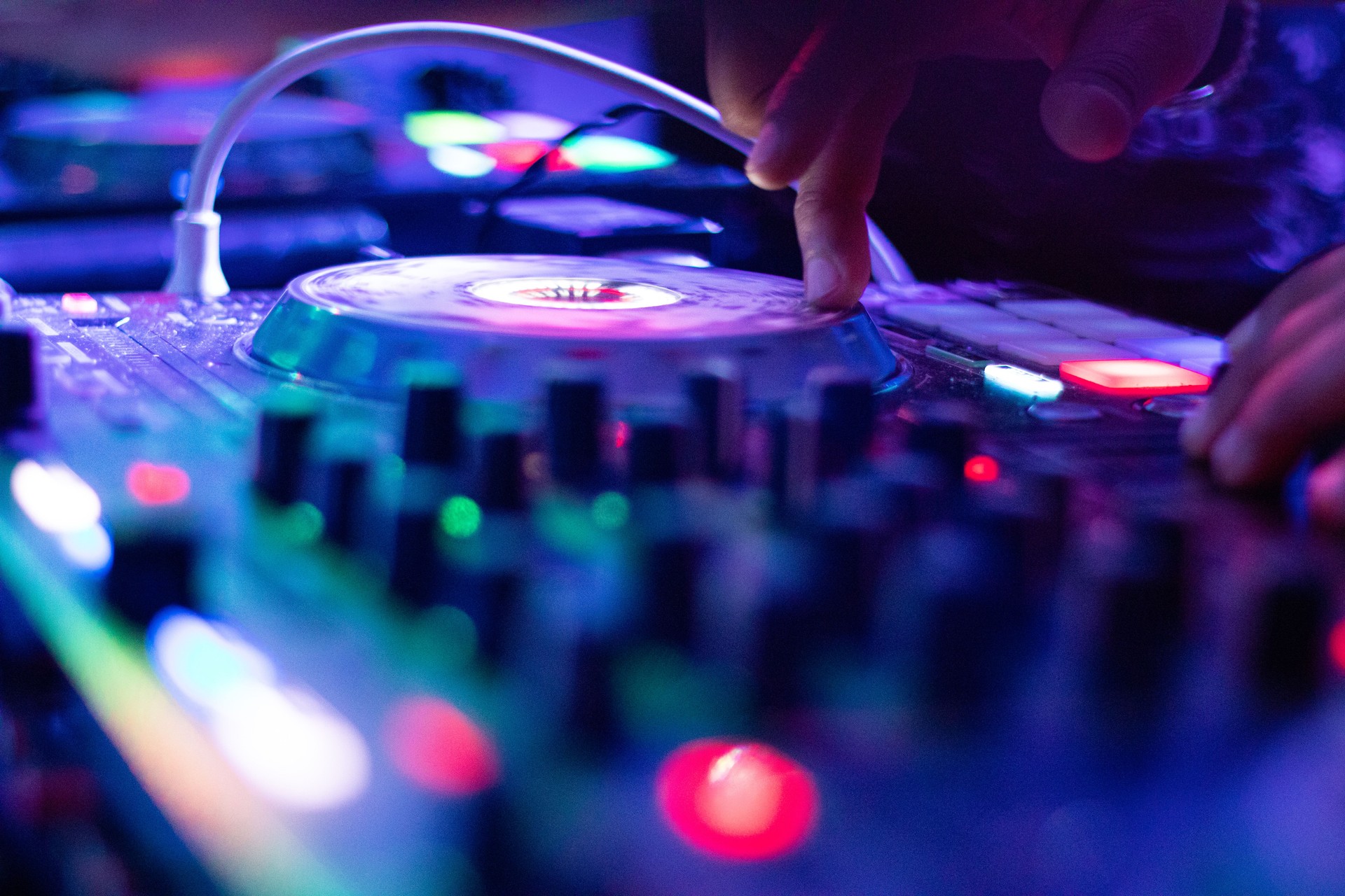 Professional Dj Performing Live Mixes at an Exciting Nightclub Party with Colorful Lighting Effects.
