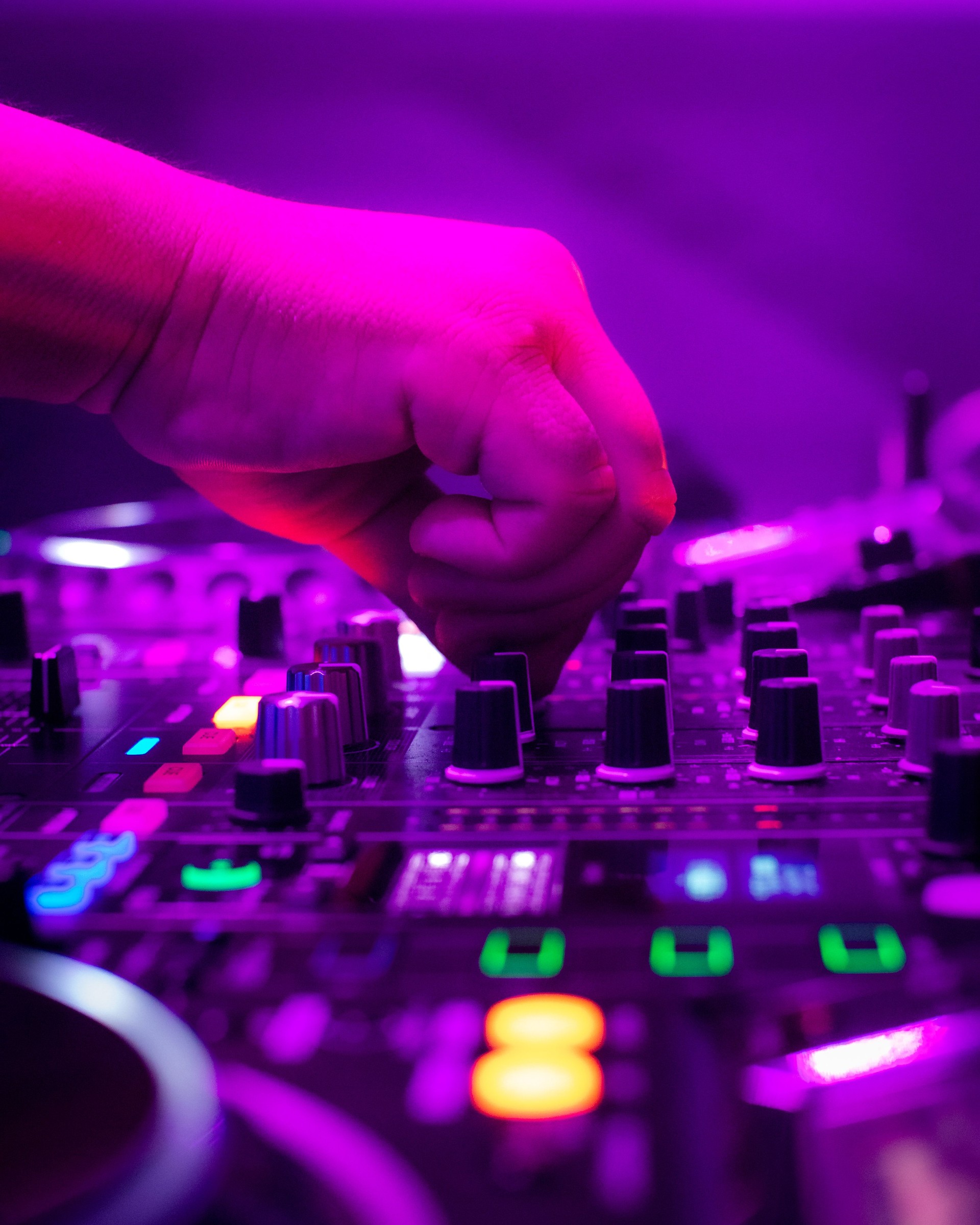 A DJ mixing on a board in a club environment